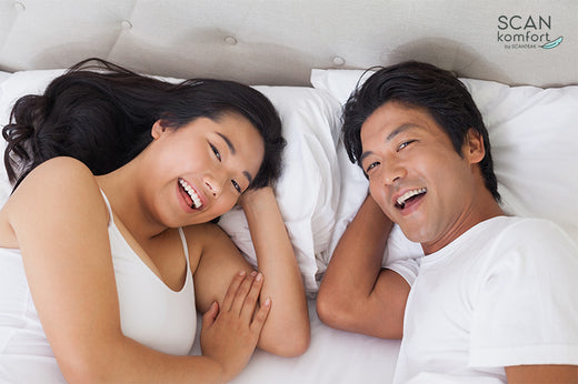 Happy couple wearing white in the bed